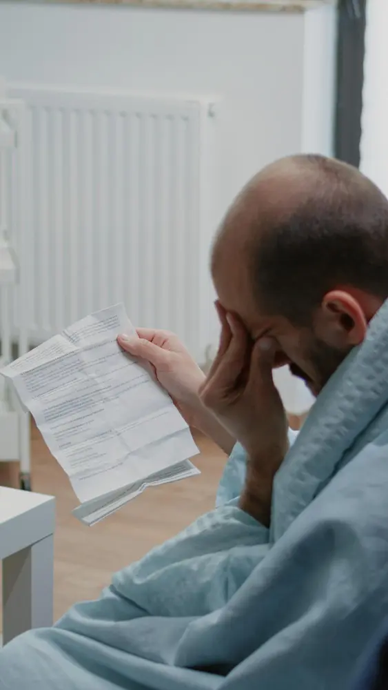 Homem doente lendo uma carta de negativa de cobertura do plano de saúde